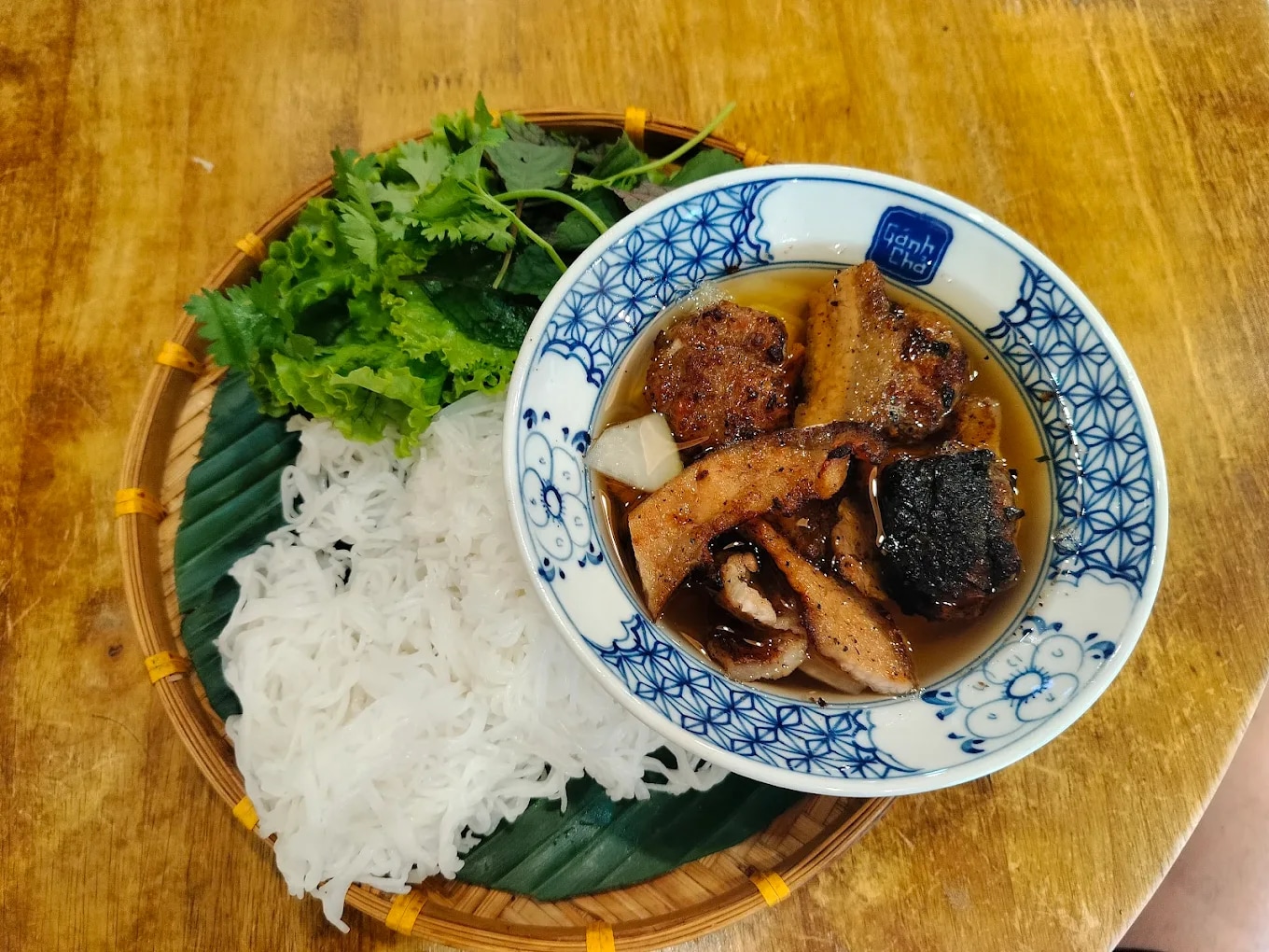 The grilled pork and tangy-sweet dipping sauce are marinated and prepared in true Hanoi style